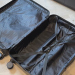 open suitcase lying on the floor while stuffed packing cubes with clothes are packed inside it