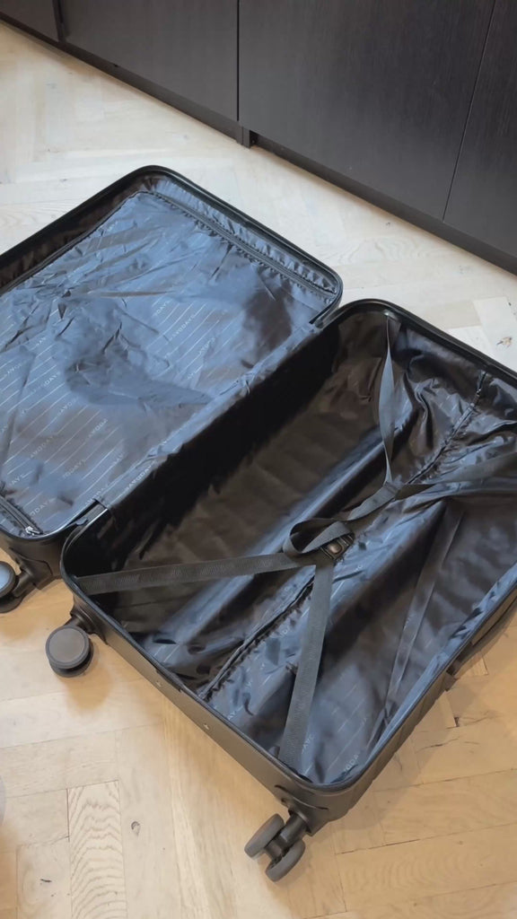 open suitcase lying on the floor while stuffed packing cubes with clothes are packed inside it